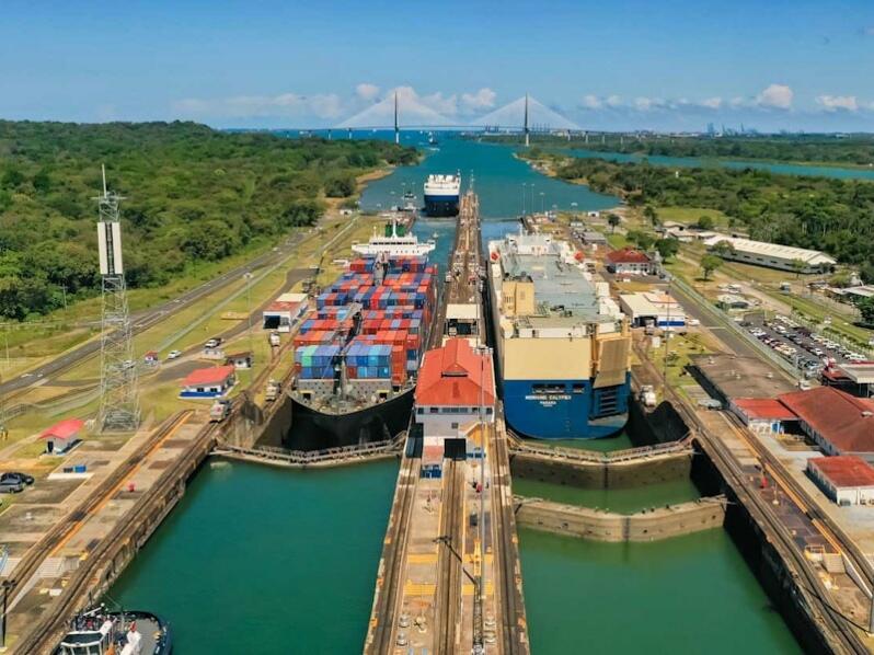 Cargo vessels navigating the locks under structured Panama Canal autonomy to maintain global trade efficiency.
